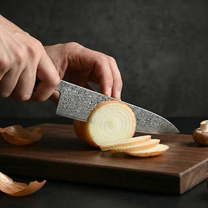 Cuchillo cortando cebolla sobre tabla